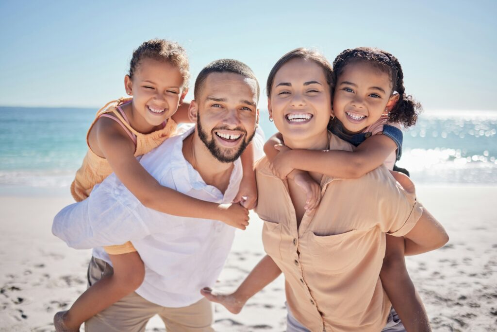 Care, young and happy family with kids walking along the beach in hawaii. Portrait mother and fathe