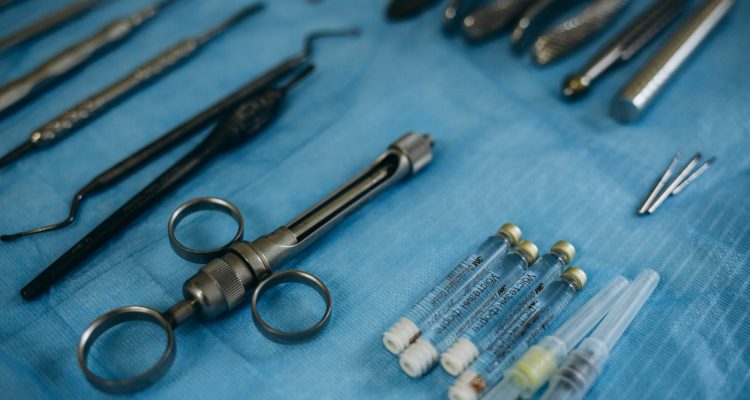 Photo of a set of steril dentistry tools or instruments lying on a light blue table