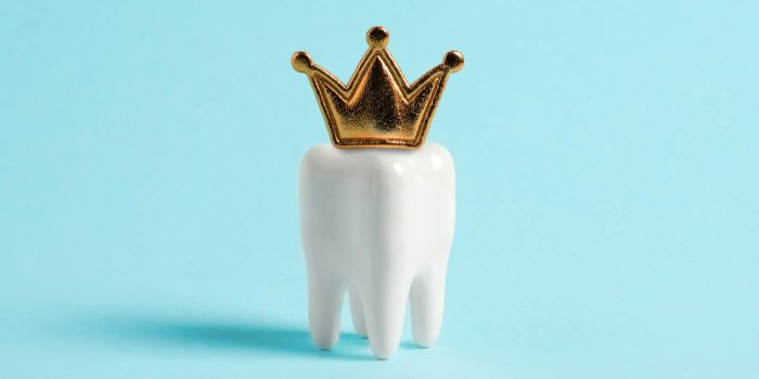 Tooth in the crown on blue background.