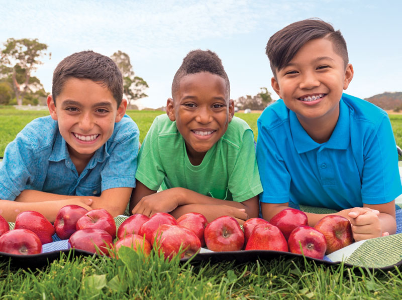 Three boys with apples.